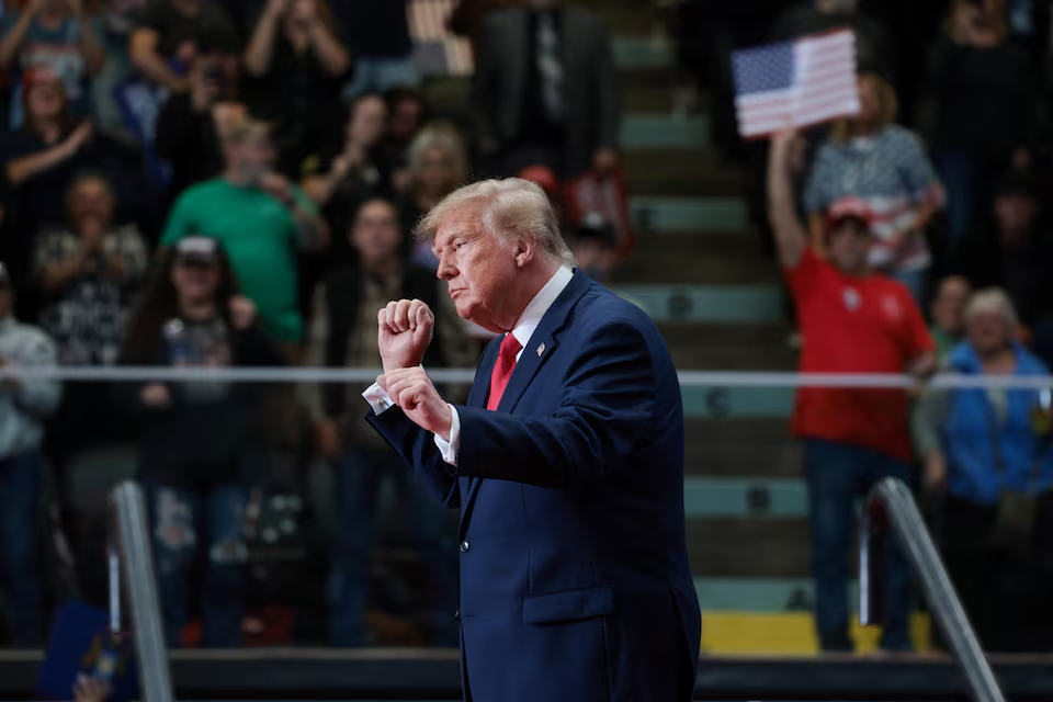 Donald Trump gestures during a political rally in Michigan as supporters watch.